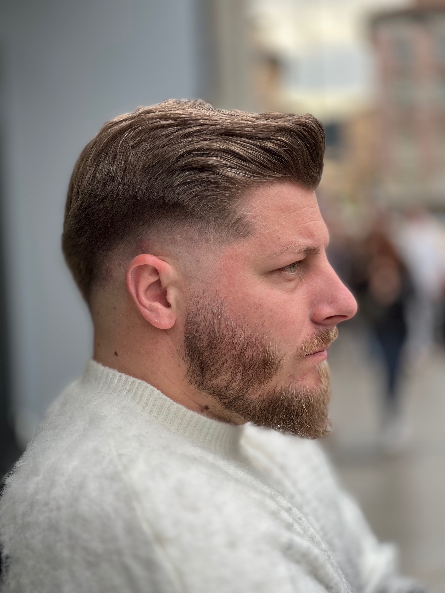 Men's textured swept-back haircut with a skin fade and groomed beard at Hair Studio Frizerie in Bergamo.