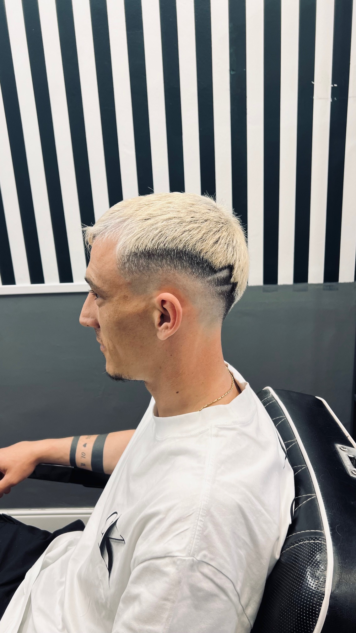 Men's blonde haircut featuring a skin fade and custom shaved design at Hair Studio Frizerie in Bergamo.